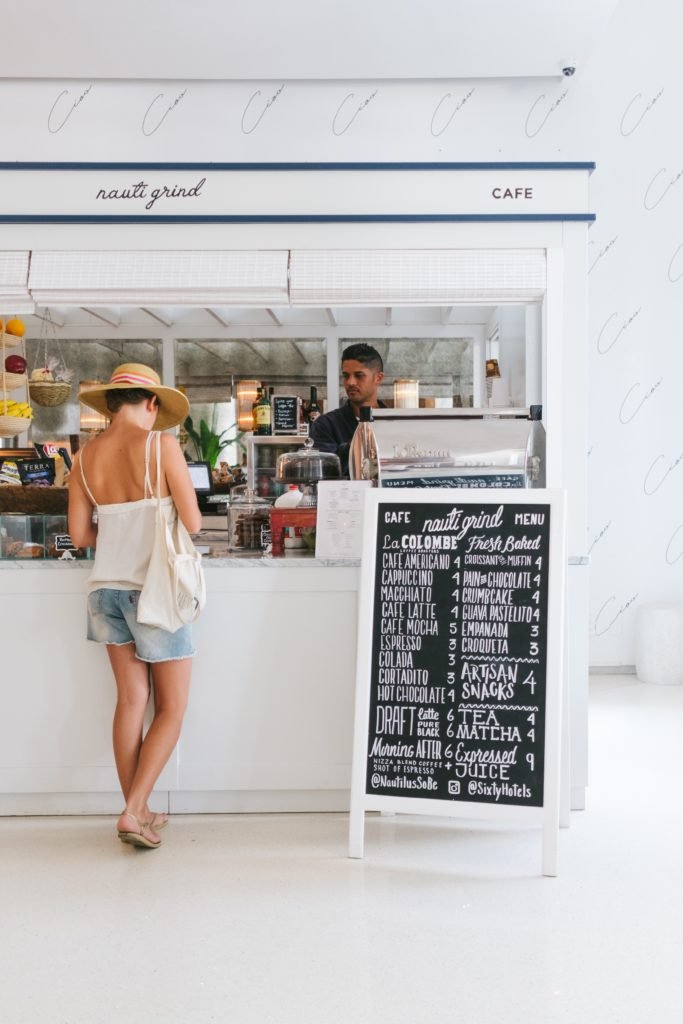 Woman buying coffee at a small coffee shop