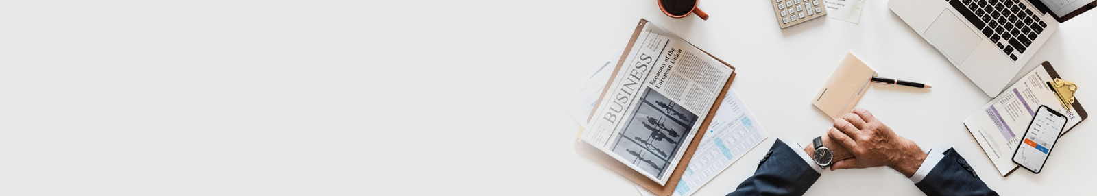 laptop, newspaper, cellphone, pen on the table