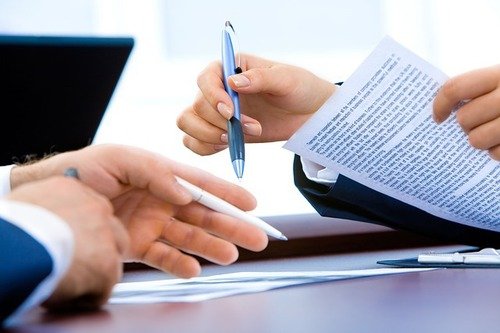 two hands sigining documents