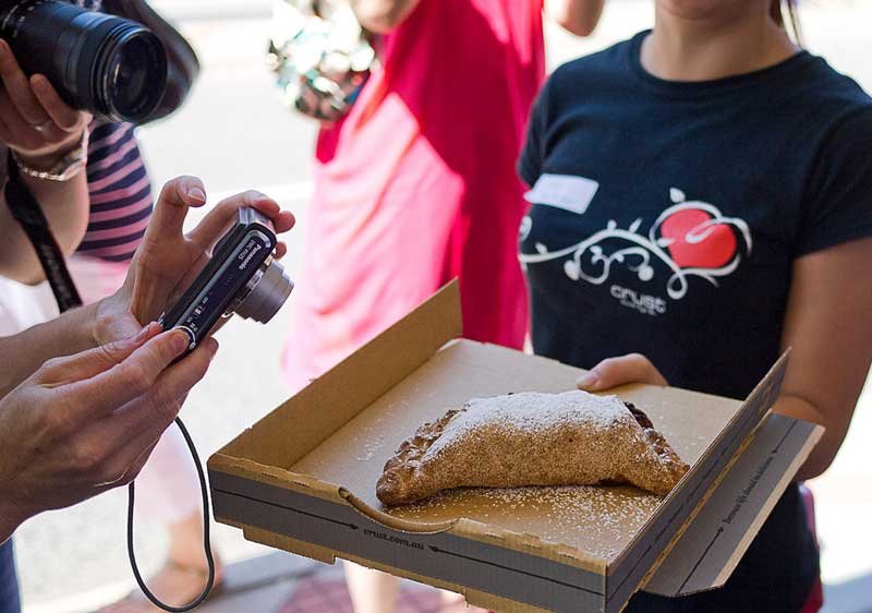 a girl holding a pizza role