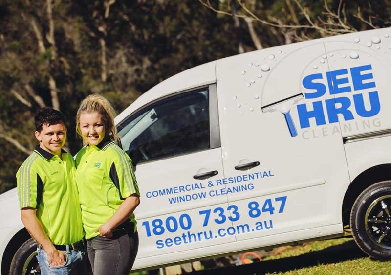 smiling man and woman in "See Thru" car background