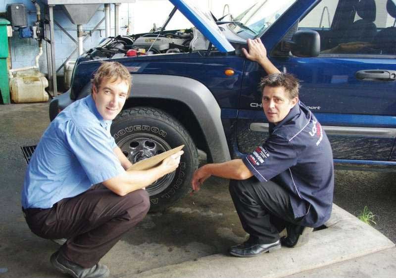 two men checking a car