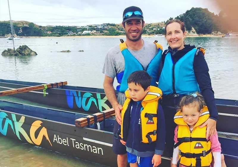 Happy family in life vests with a sea background and a boat, enjoying a day on the water